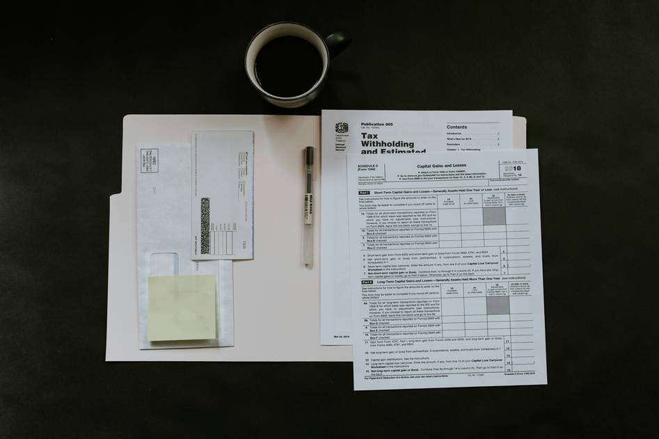 Author reviewing credit card benefits guide at desk with rental agreement documents