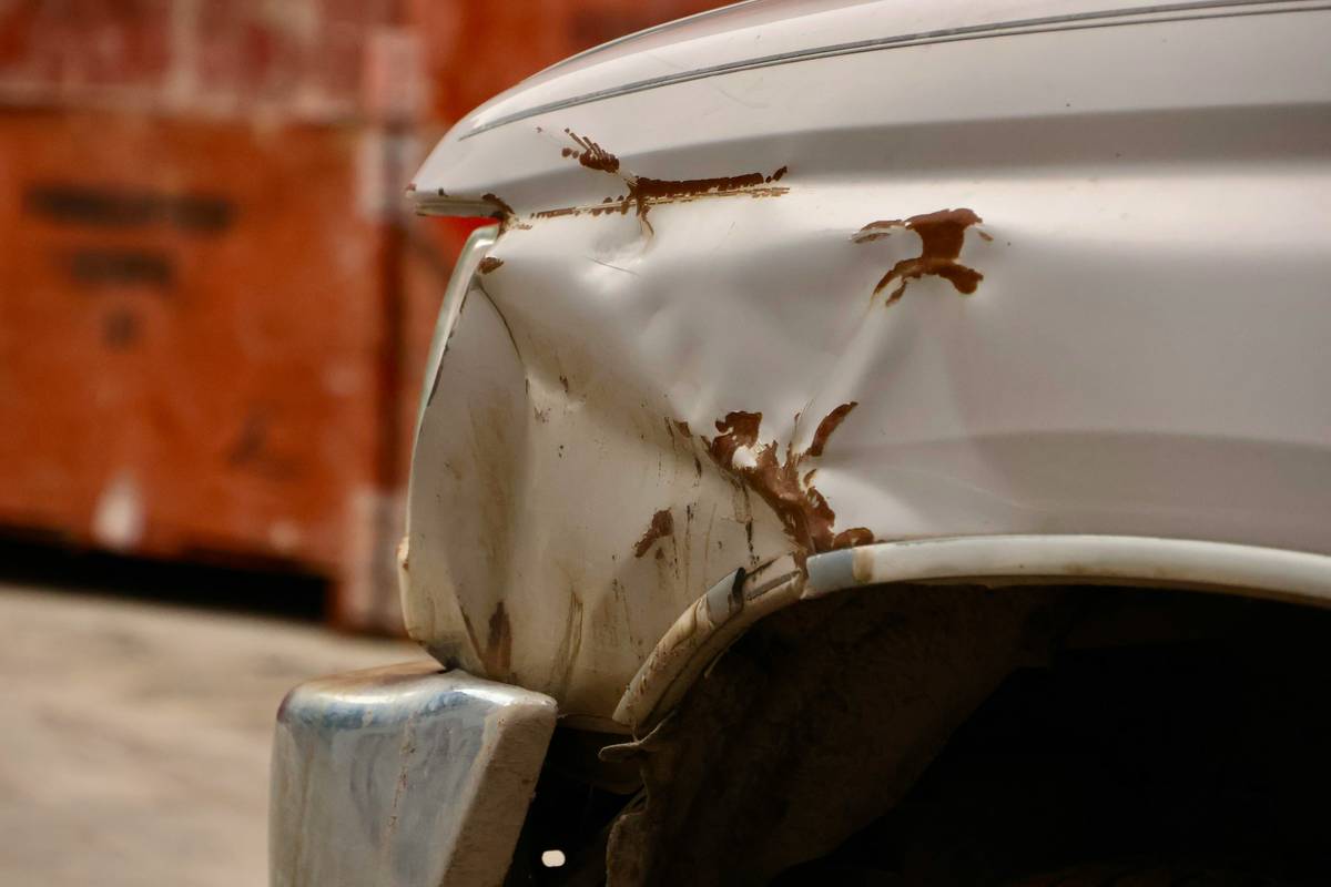 Rental car with minor bumper damage tagged with Collision Damage Waiver coverage label