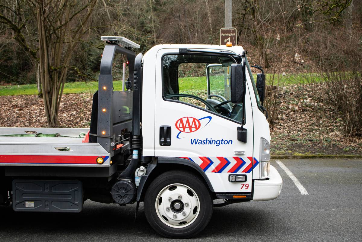 Roadside Assistance Coverage shown with a stranded rental car being towed on a rural highway